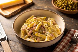 piatto di penne rigate con prosciutto, piselli e panna cucinato da liffo, robot da cucina dotato di intelligenza artificiale