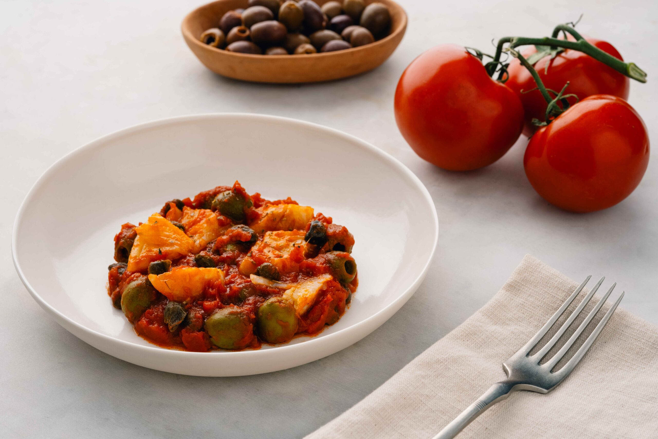 Cod with tomato, capers and olives